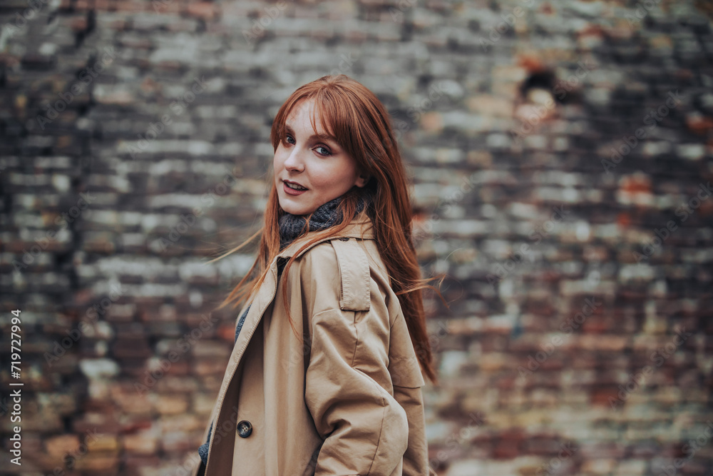 A trendy young ginger girl looking over shoulder at the camera outdoors. A trendy young ginger girl looking over shoulder at the camera outdoors.