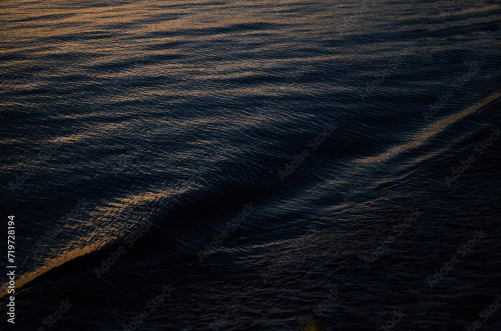 Close-up minimal image of waves in dark blue lake water.