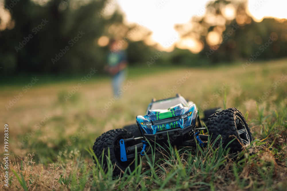 Obraz premium Selective focus on an electric toy race car running in the grass in nature.