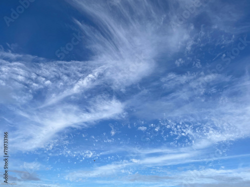 Blue sky with sparse fluffy clouds. Cloud wallpaper.