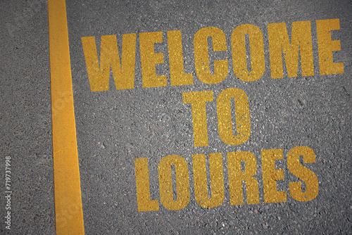 asphalt road with text welcome to Loures near yellow line. photo