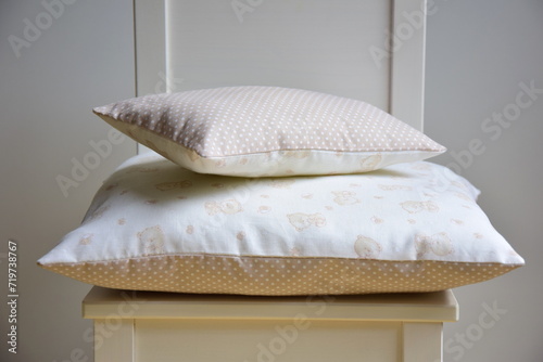 Cotton cushion with pattern of bears and dots, handmade, on a white chair, noble background in the children's room