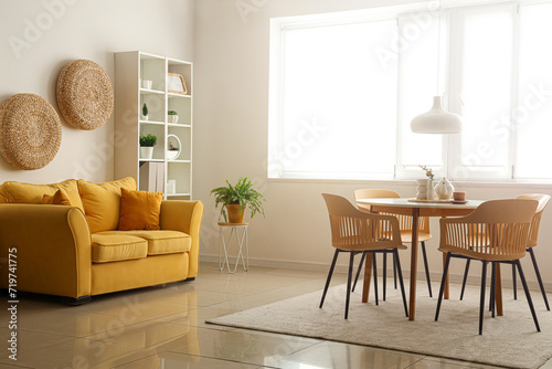 Interior of stylish living room with table, chairs and sofa