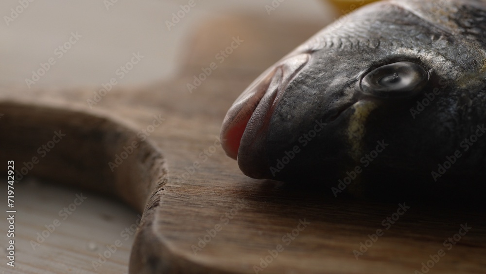 Raw fish head on a cutting board. Selective focus, close-up.