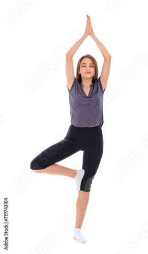 Young woman doing yoga on w...
