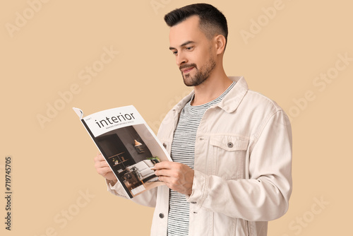 Handsome man reading magazi...