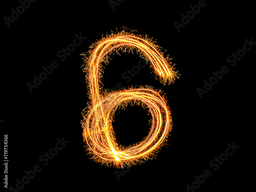 Alphabet and Number six sparklers on black background by light painting.number 6 sparkling golden for party and Celebrate