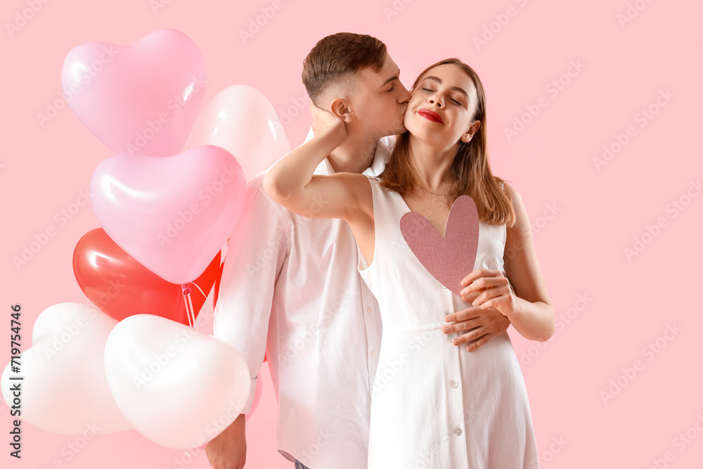 Happy young couple with beautiful heart-shaped balloons on pink background. Valentine's Day celebration Happy young couple with beautiful heart-shaped balloons on pink background. Valentine's Day celebration