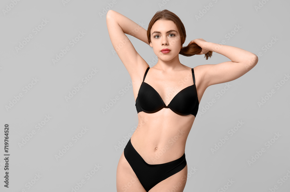 Attractive young woman in black underwear on light background Attractive young woman in black underwear on light background