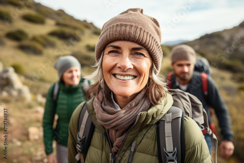 Senior woman hiking with a group in the mountains, depicting adventure and exploration in later years. Concept of active lifestyle and nature connection in aging. Generative Ai.