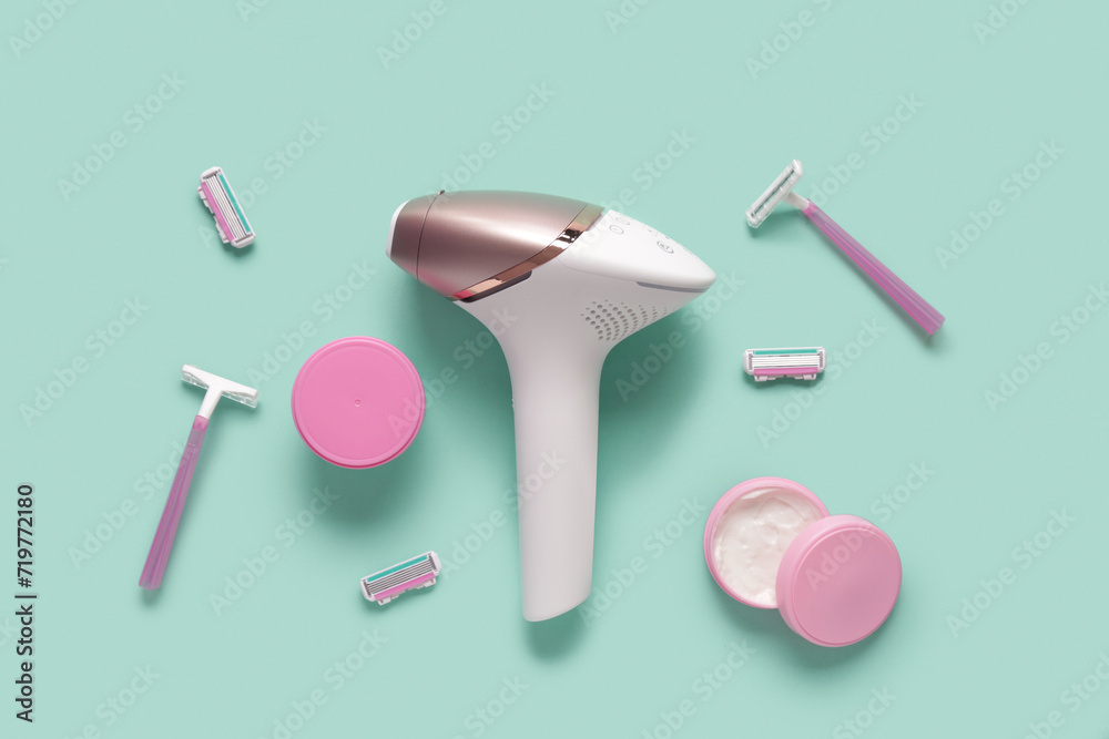 Modern photoepilator with razors and jars of cream on turquoise background Modern photoepilator with razors and jars of cream on turquoise background