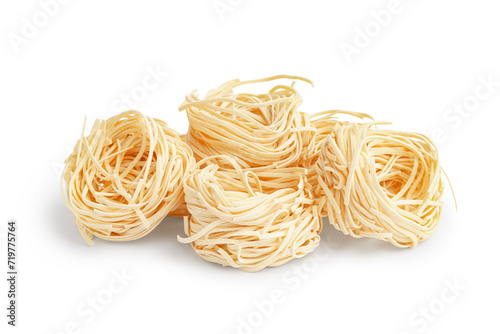 Uncooked pasta nests on white background