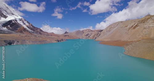 Drone shot of Tilicho Lake at Annapurna mountain circuit, World's highest altitude lake under blue cear sky with clouds, mountains, happy nature, chilly weather Nepal 4K photo