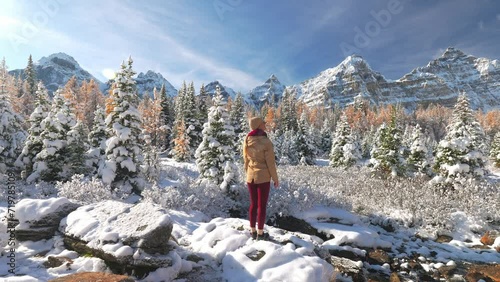 Woman standing in snowy landscape looking at Valley of the Ten Peaks photo