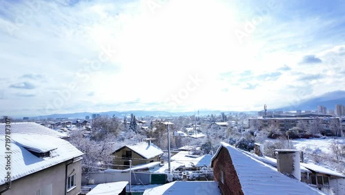 walking out on the balcony to discover a snow-covered rooftops on a cold winter day