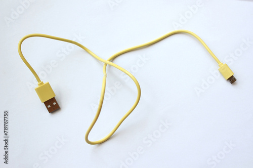 yellow USB cable on white background. USB and USB-mini cable connectors close-up. A patch cable or patch cord or patch lead.