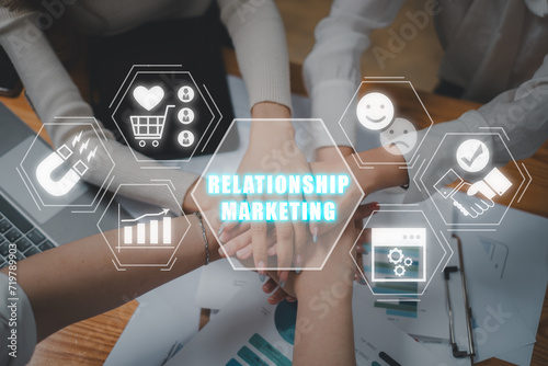 Fototapeta Naklejka Na Ścianę i Meble -  Relationship marketing concept, Business team putting their hands on top of each other with relationship marketing icon on virtual screen. Public Relations, Strategy, SEO, Social Media.