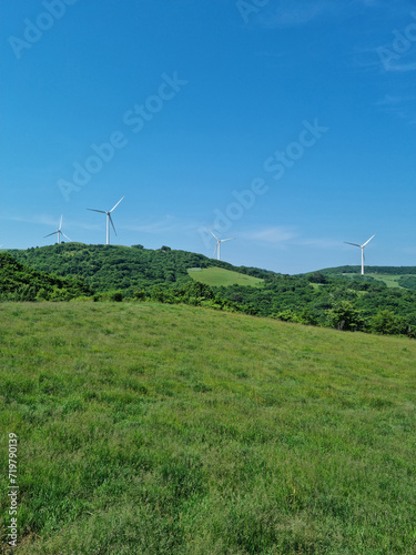 This is a landscape of a meadow with a wind turbine.