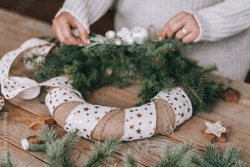 Close-up photo of female hands making christmas wreath