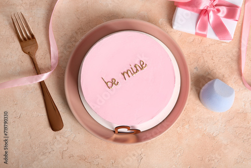 Plate with pink bento cake and gift box on beige grunge background. Valentine's Day celebration