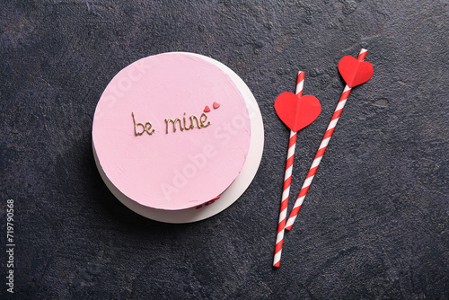 Pink bento cake with straws on black grunge background. Valentine's Day celebration