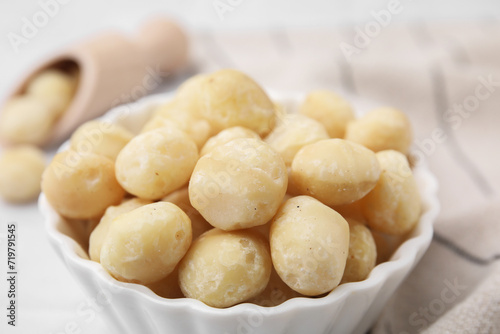 Tasty peeled Macadamia nuts in bowl on table, closeup