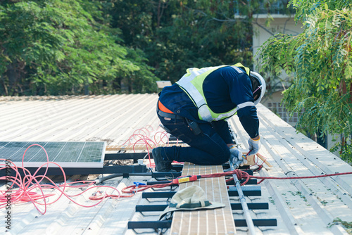 Worker Technicians are working to construct solar panels system on roof. Installing solar photovoltaic panel system. Men technicians carrying photovoltaic solar modules on roof.