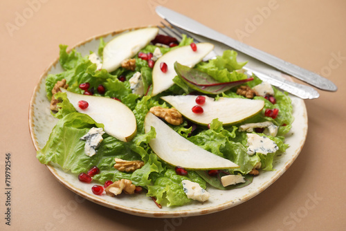 Delicious pear salad and cutlery on beige background, closeup
