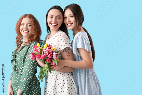 Happy young women with bouq...
