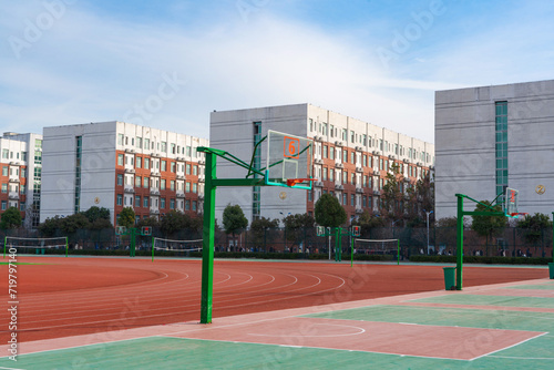 In the school yard:a basketball stands and school building.