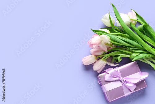 Bouquet of beautiful tulips and gift box on purple background. International Women's Day