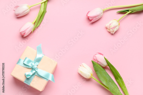 Frame made of beautiful tulips and gift box on pink background. International Women's Day