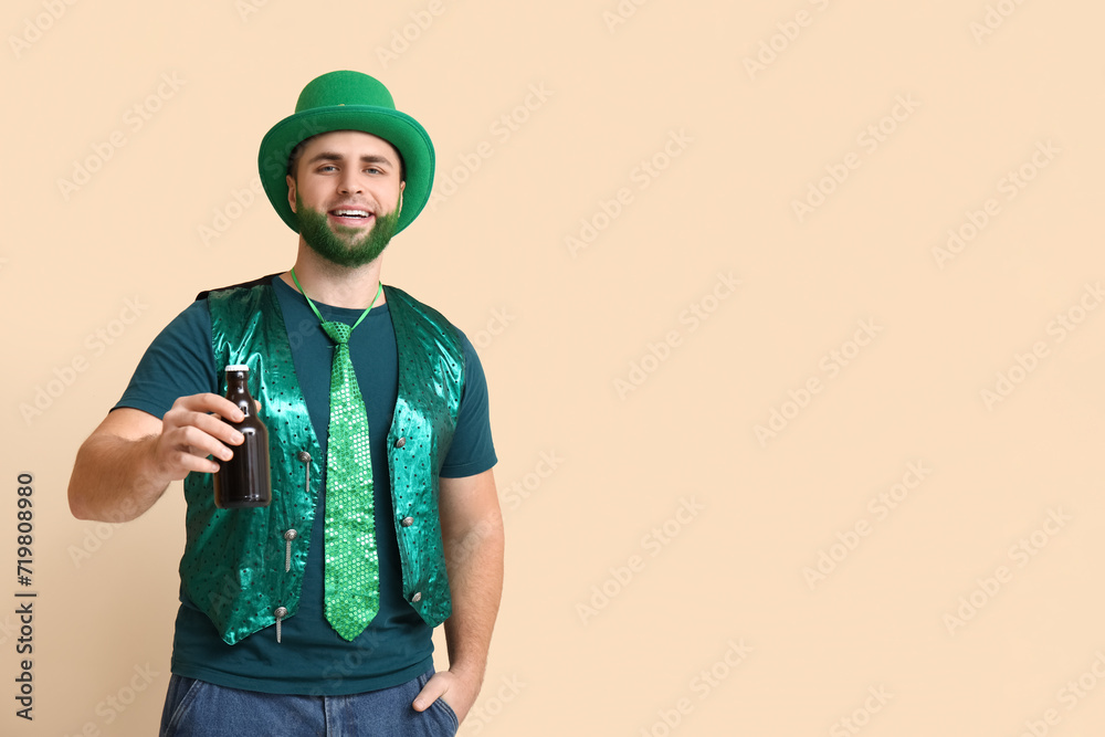 Young man in leprechaun hat with green beard holding bottle of beer on beige background. St. Patrick's Day celebration Young man in leprechaun hat with green beard holding bottle of beer on beige background. St. Patrick's Day celebration