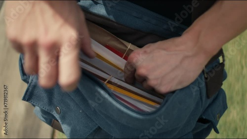 Postman trying to find a letter in his bag photo