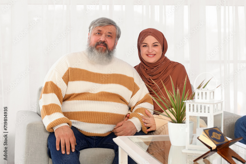Mature Muslim couple sitting on sofa at home. Ramadan celebration Mature Muslim couple sitting on sofa at home. Ramadan celebration