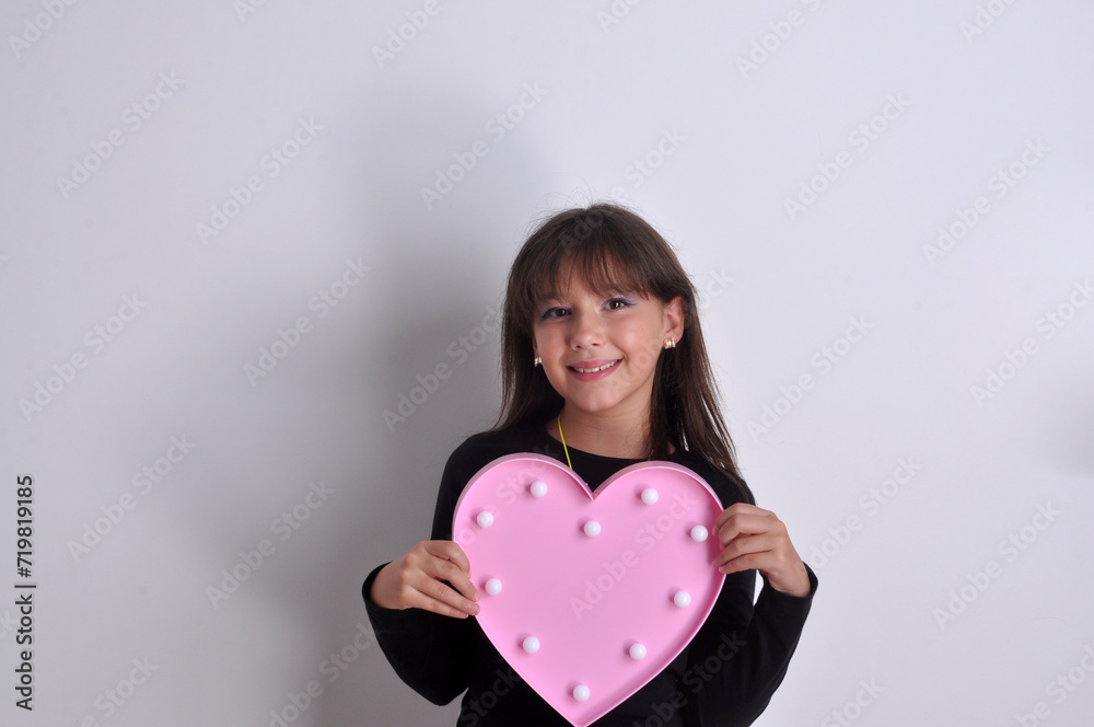 garota pré adolescente segurando coração rosa nas mãos garota pré adolescente segurando coração rosa nas mãos