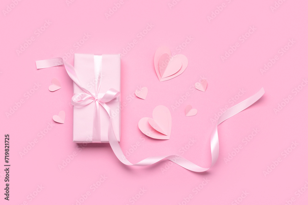 Composition with gift box and paper hearts for Valentine's Day celebration on pink background