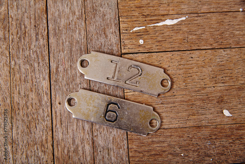 Vintage Number Tags 12 and 6 on Rustic Wooden Texture, Top View