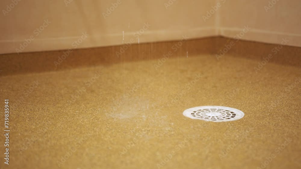 Shower water flowing down train over lino flooring