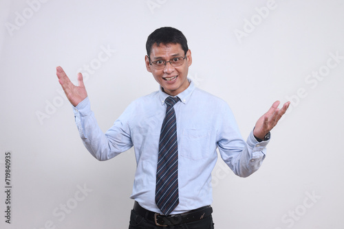 Adult Asian friendly businessman in shirt and tie raising both hands showing welcoming or greeting gesture  