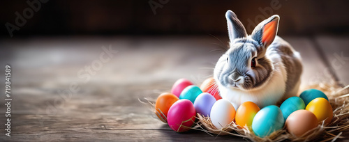 Advertising banner for Easter Day with a picture of a hare and Easter eggs on a wooden background with free copy space