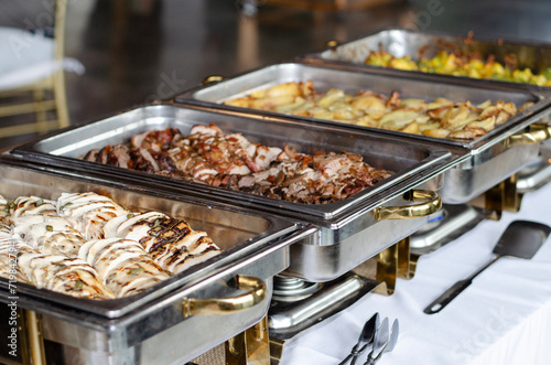 traditional buffet style dinner at wedding with grilled chicken and roast beef in warm metal serving trays
