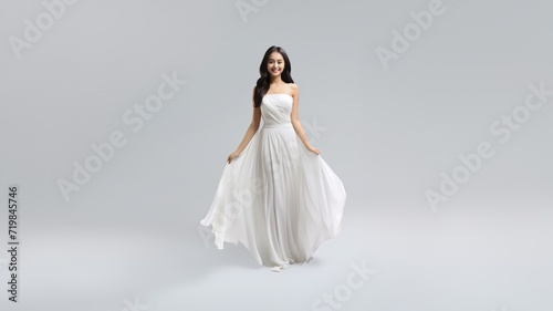 full-body fashion portrait of a beautiful woman in a long, flowing white gala dress, the light fabric gracefully draping her figure against a chic white and gray background. Generative AI. photo