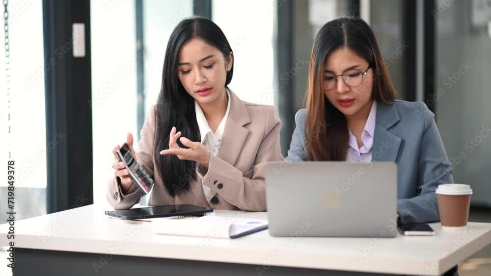 Businesswoman leading team meeting and using tablet and laptop computer with financial in office