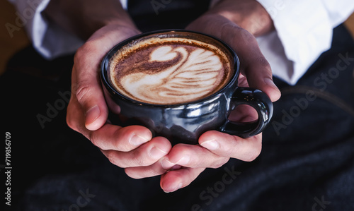 Close up barista holding a cup of latte art coffee