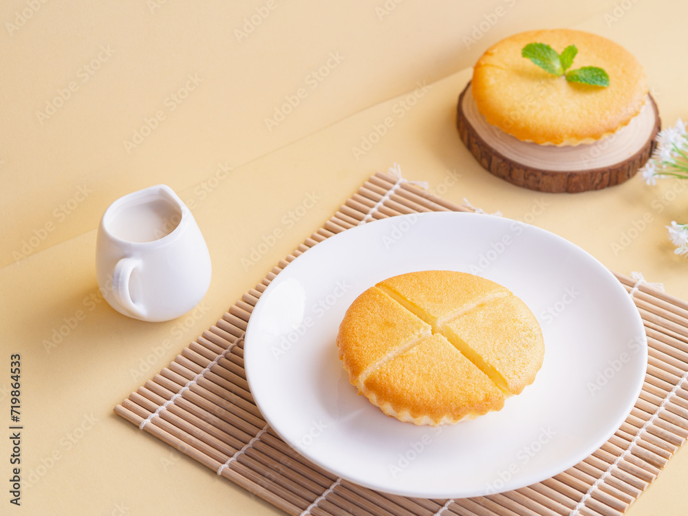 Delicious sliced butter cake in white plate on beige background. Minimalist product concept Delicious sliced butter cake in white plate on beige background. Minimalist product concept
