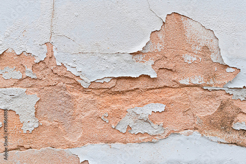 Abstract background of cracked concrete wall with peeling paint.