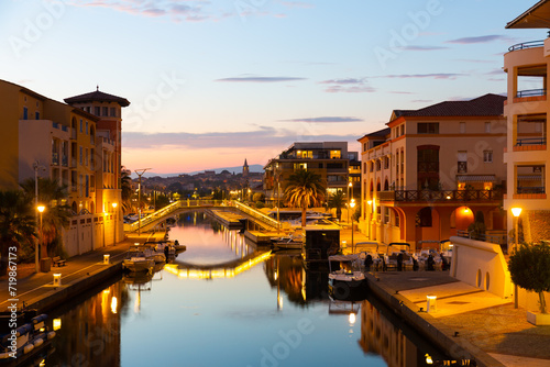 Twilight in Frejus, South of France. View of Buildings and bridge across Reyran River illuminated by city lights. photo