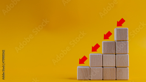 Business decrease concept abstract yellow background. Red arrow and wooden stairs bock photo