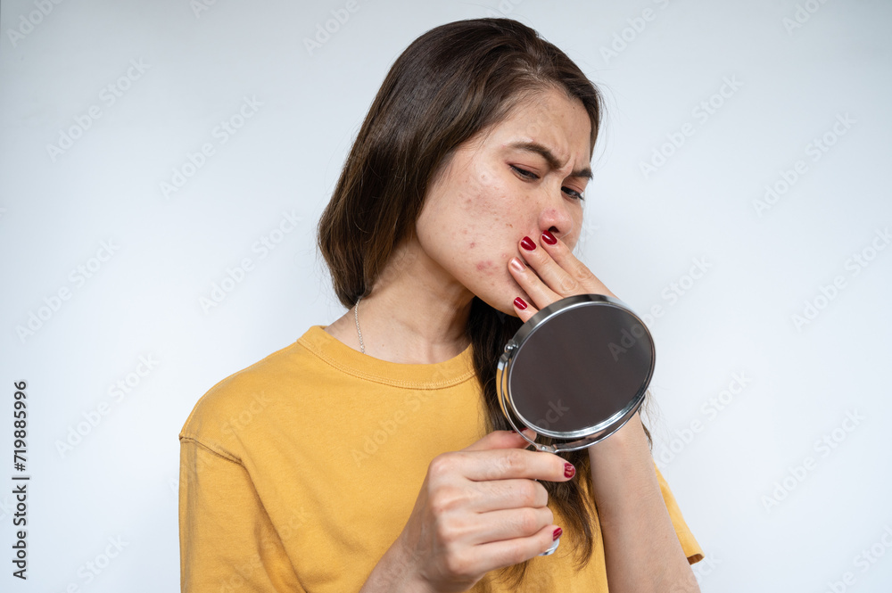 Portrait of Asian woman worry about her face when she saw the problem of acne inflammation occur on her face.